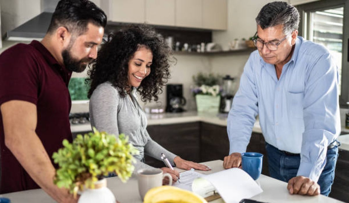 Mid adult couple filling document in the kitchen at home
